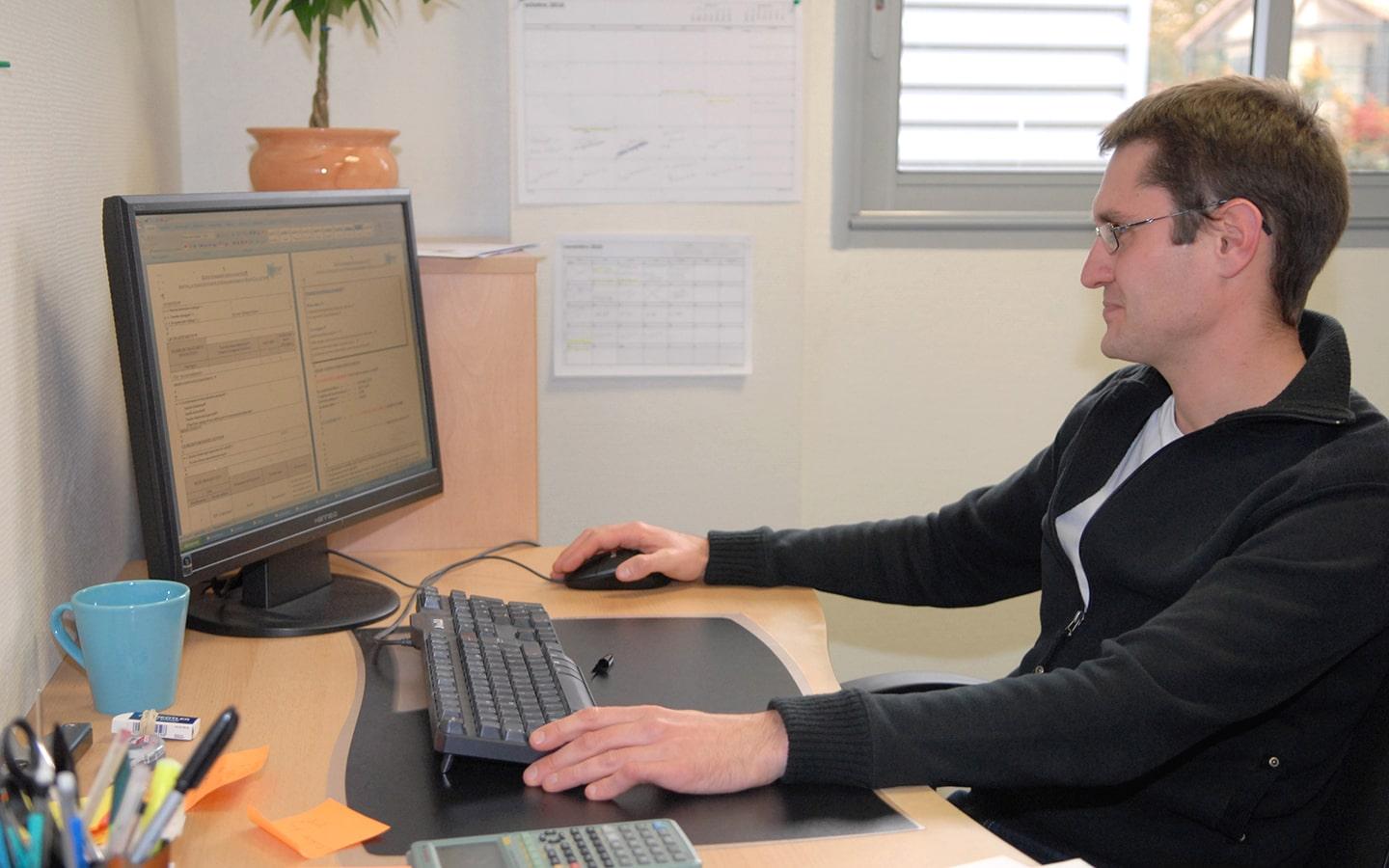 Dirigeant TPE devant ordinateur