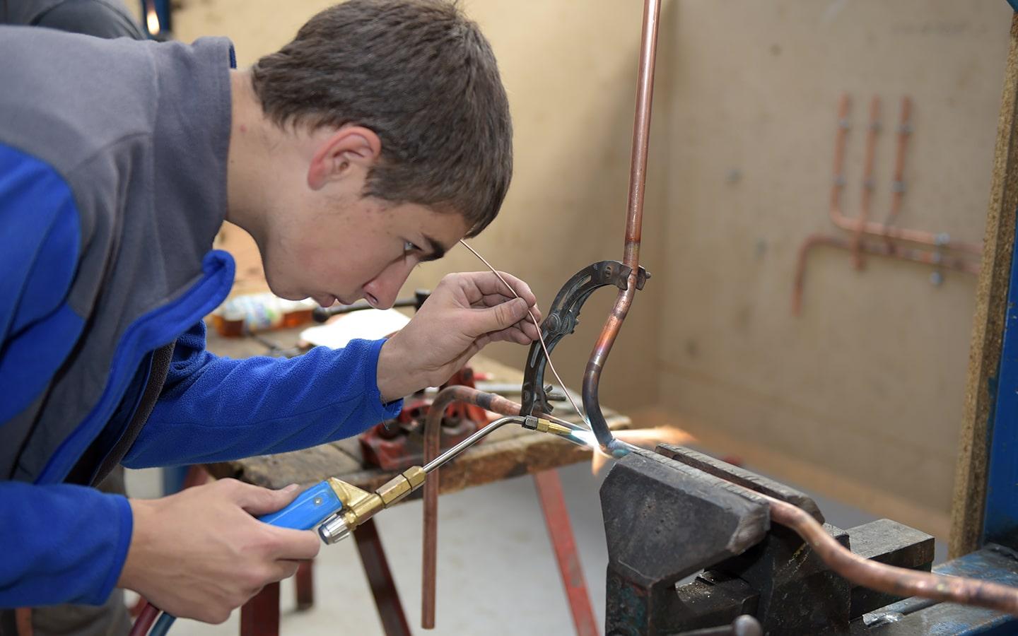 Jeune en formation de plomberie